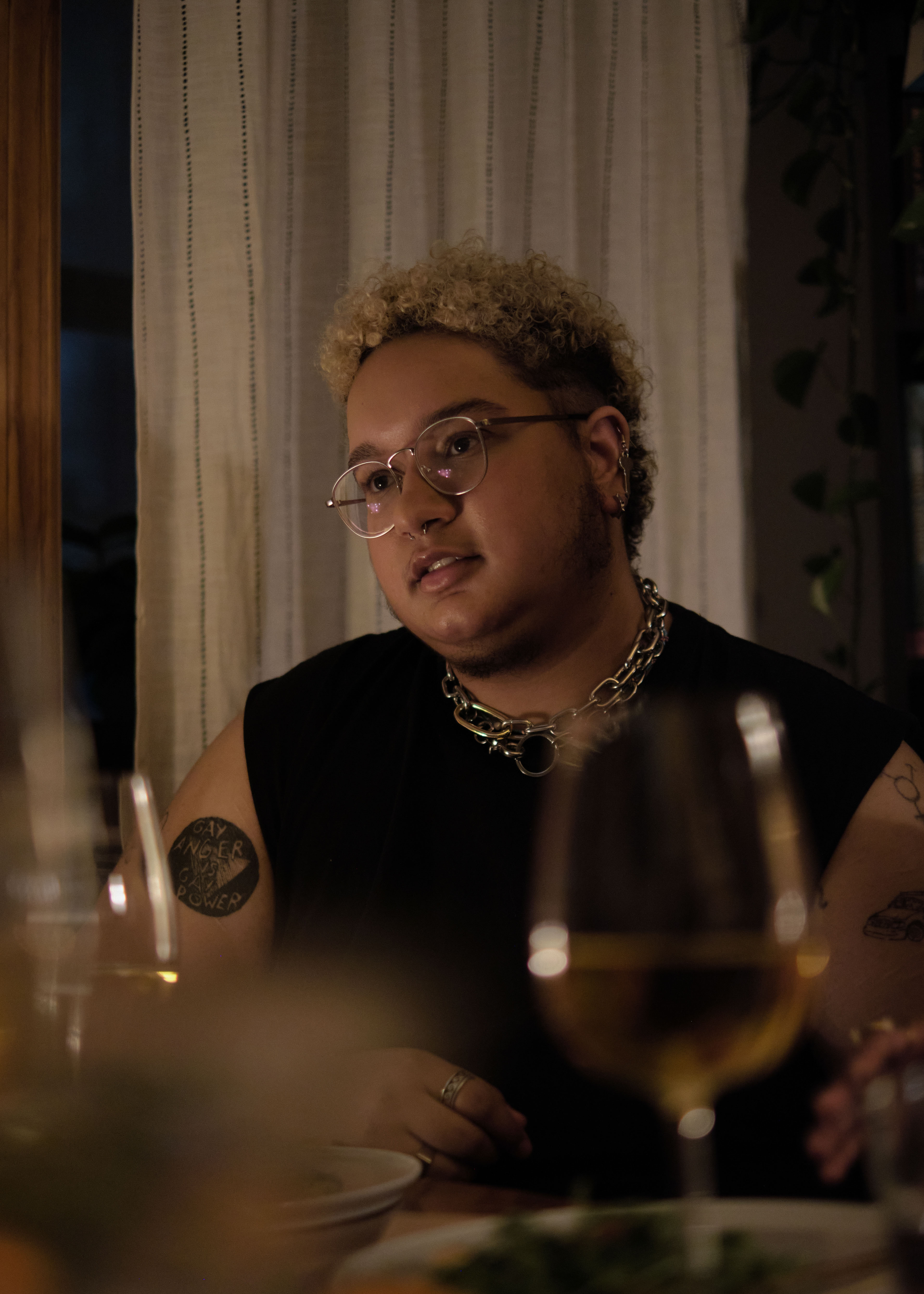 A transmasculine non-binary person at dinner in an apartment